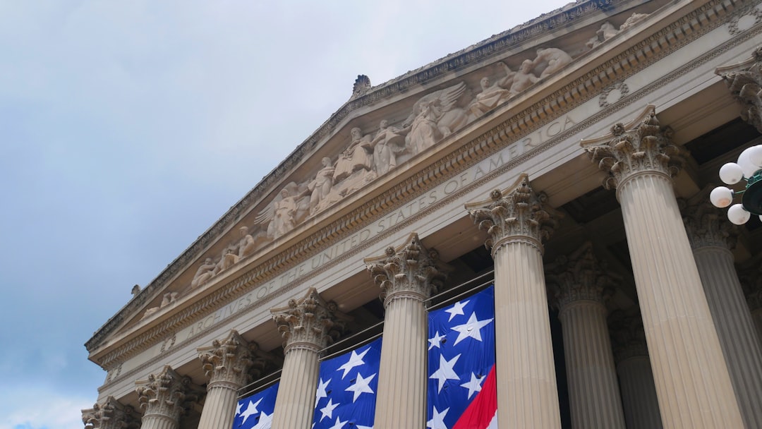 Grand building with columns and american flag banner.
