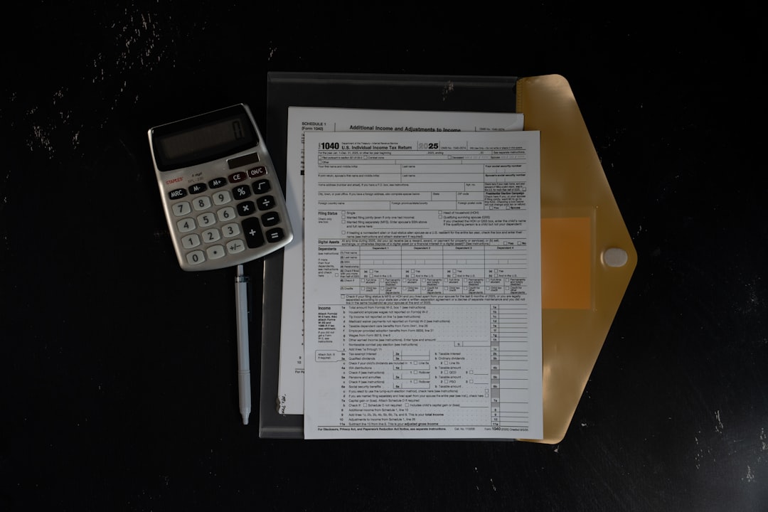 Calculator and papers in a folder on a dark surface