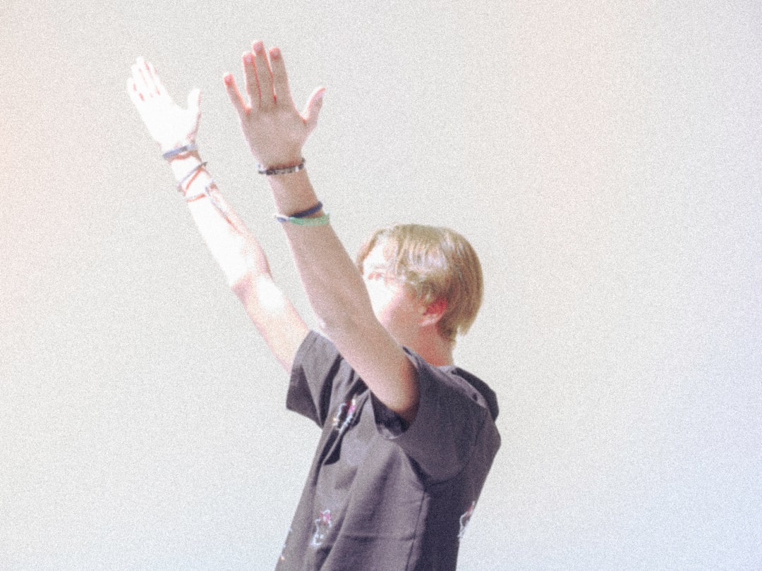 a boy is reaching up to catch a frisbee