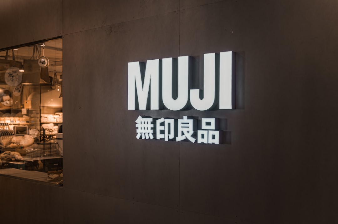 Muji logo on a dark wall with japanese characters