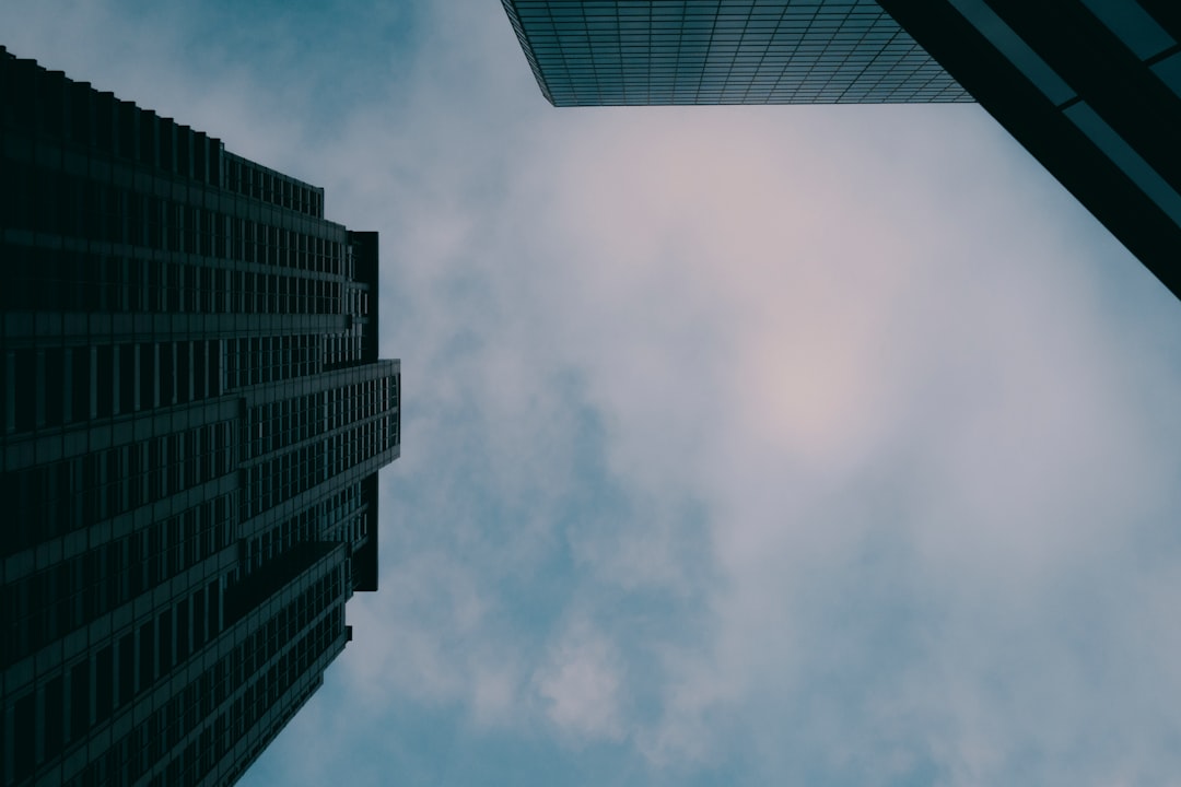 Looking up at tall buildings against a cloudy sky